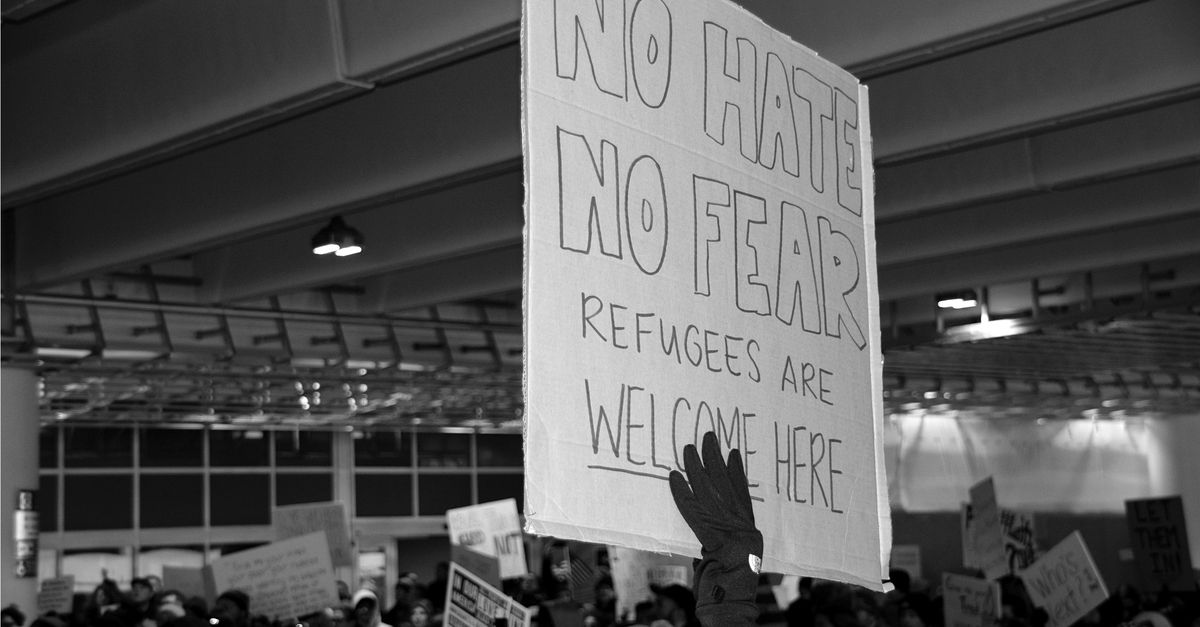 Protester holding sign that reads: "No Hate, No Fear, Refugees Are Welcome Here"