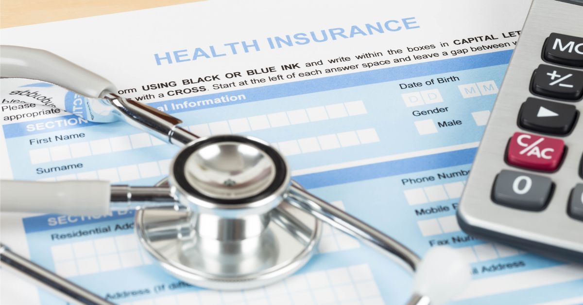 Stethoscope and calculator on top of a health care application form.