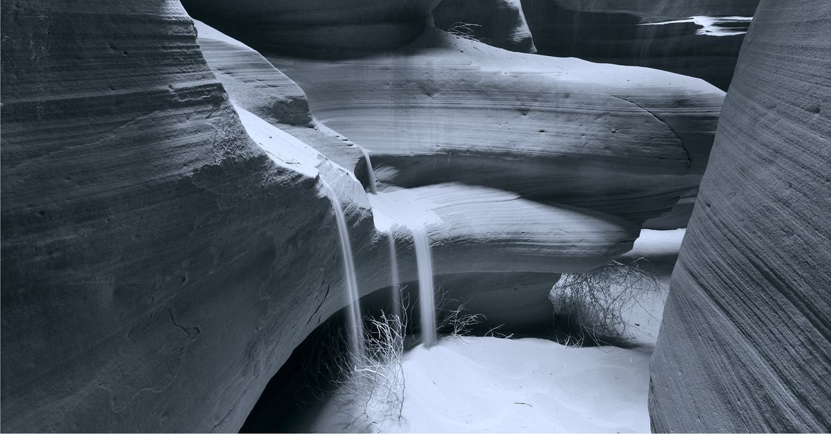 Sand running down a rock as though it were water.