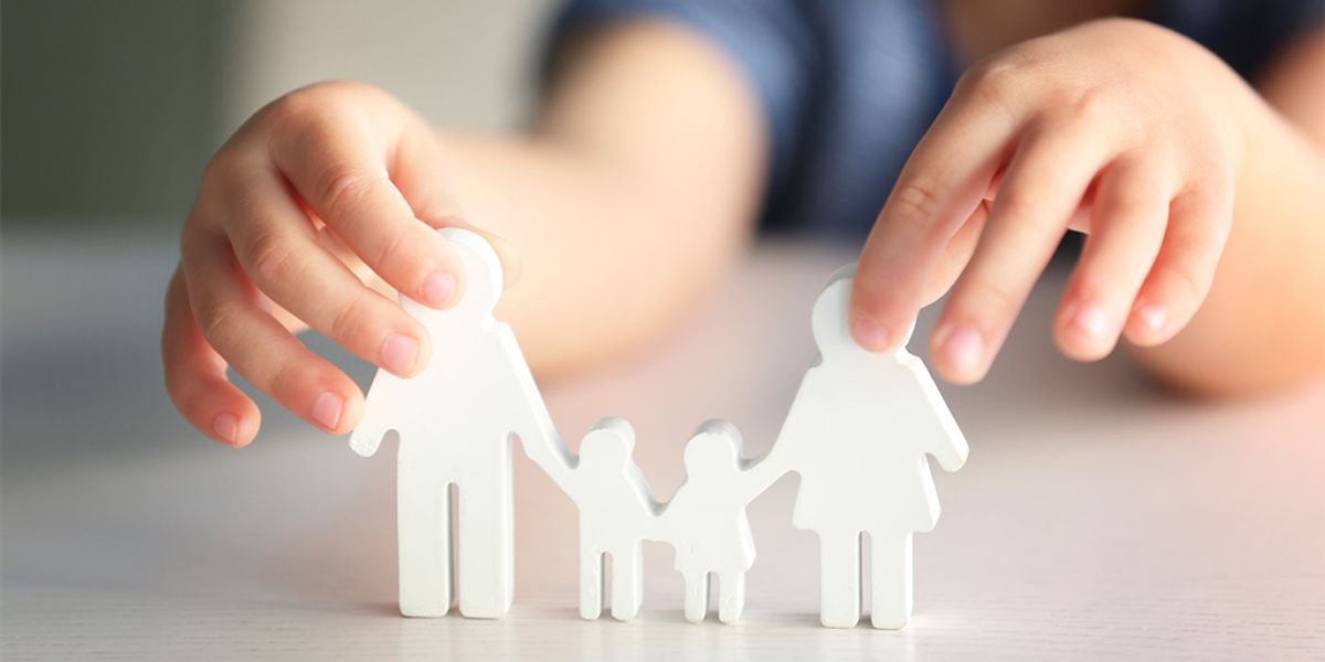 Child holding a paper cutout of a family.