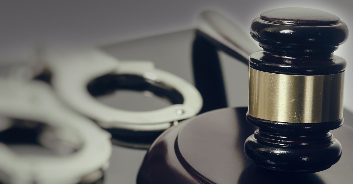 Close up of gavel, handcuffs in background