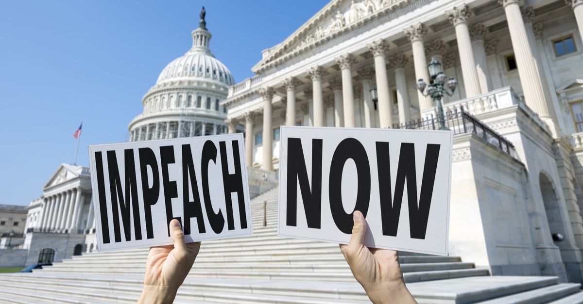 Hands holding signs reading "Impeach Now" in front of White House