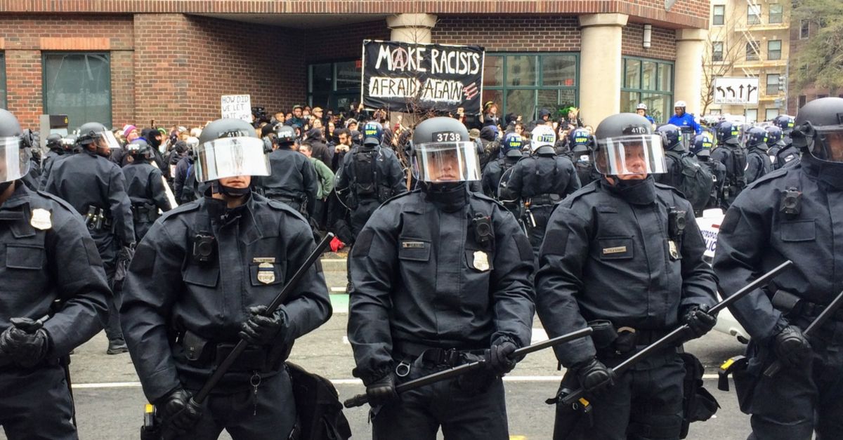 WASHINGTON, Jan. 20, 2017 -- Police in riot gear form a line around detained #DisruptJ20 protesters holding a "Make Racists Afraid Again" banner during the presidential inauguration of Donald Trump.