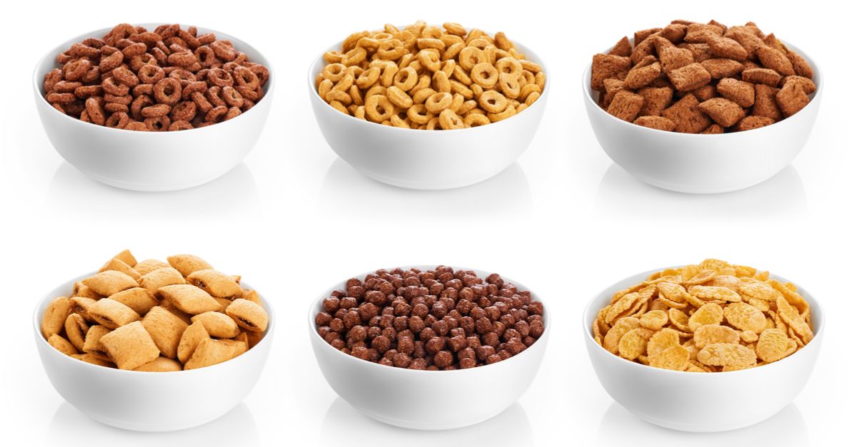 Various bowls of breakfast cereals against a white background.