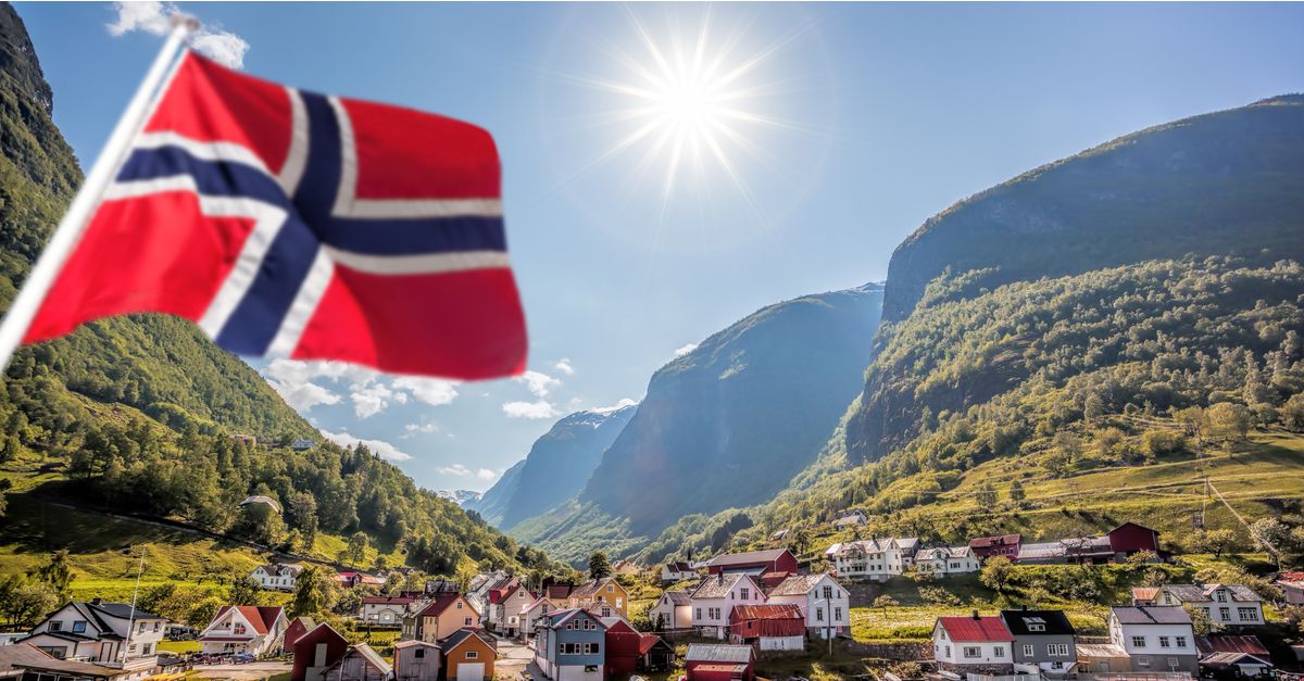 View of small fishing town with Norwegian Flag in foreground
