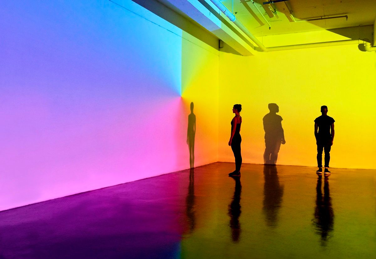 man and woman standing in a gallery space with colourful walls