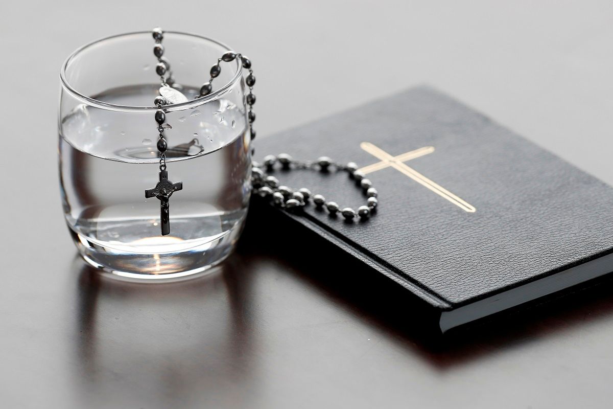 Rosary, glass of water, and holy Bible during Lent