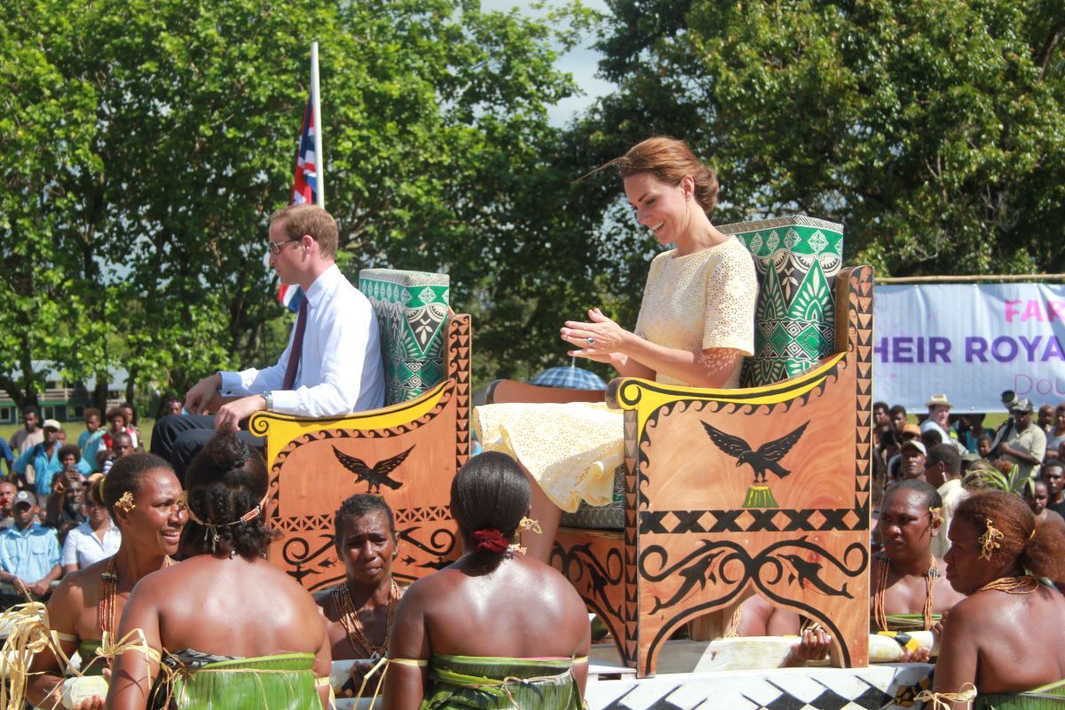 Prince William and Kate are carried on portable thrones or litters.