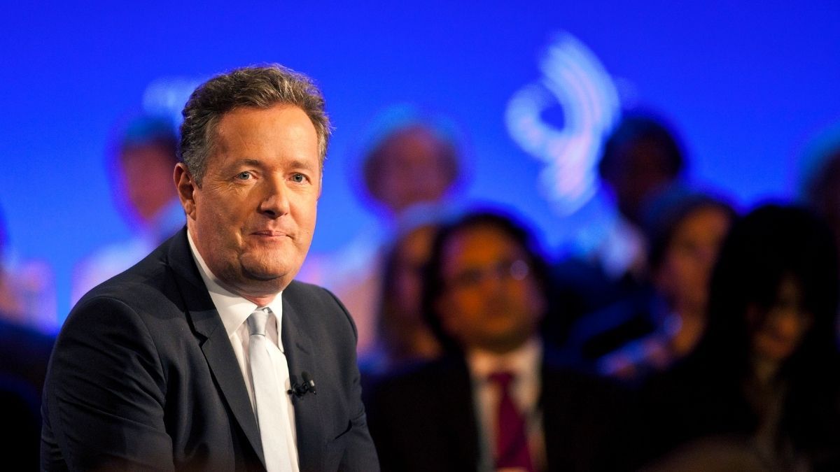 piers morgan, seen here sitting on stage, has been a critic of meghan markle