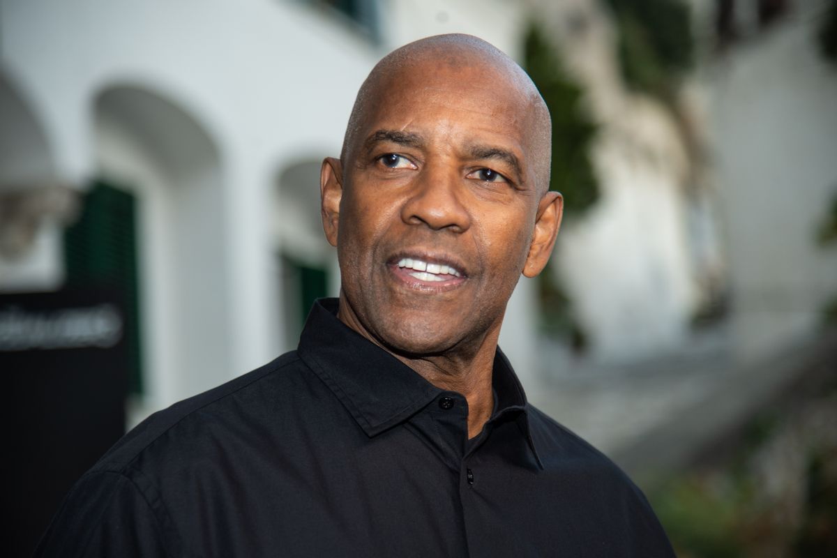 A Black man in a black shirt looks towards the camera.
