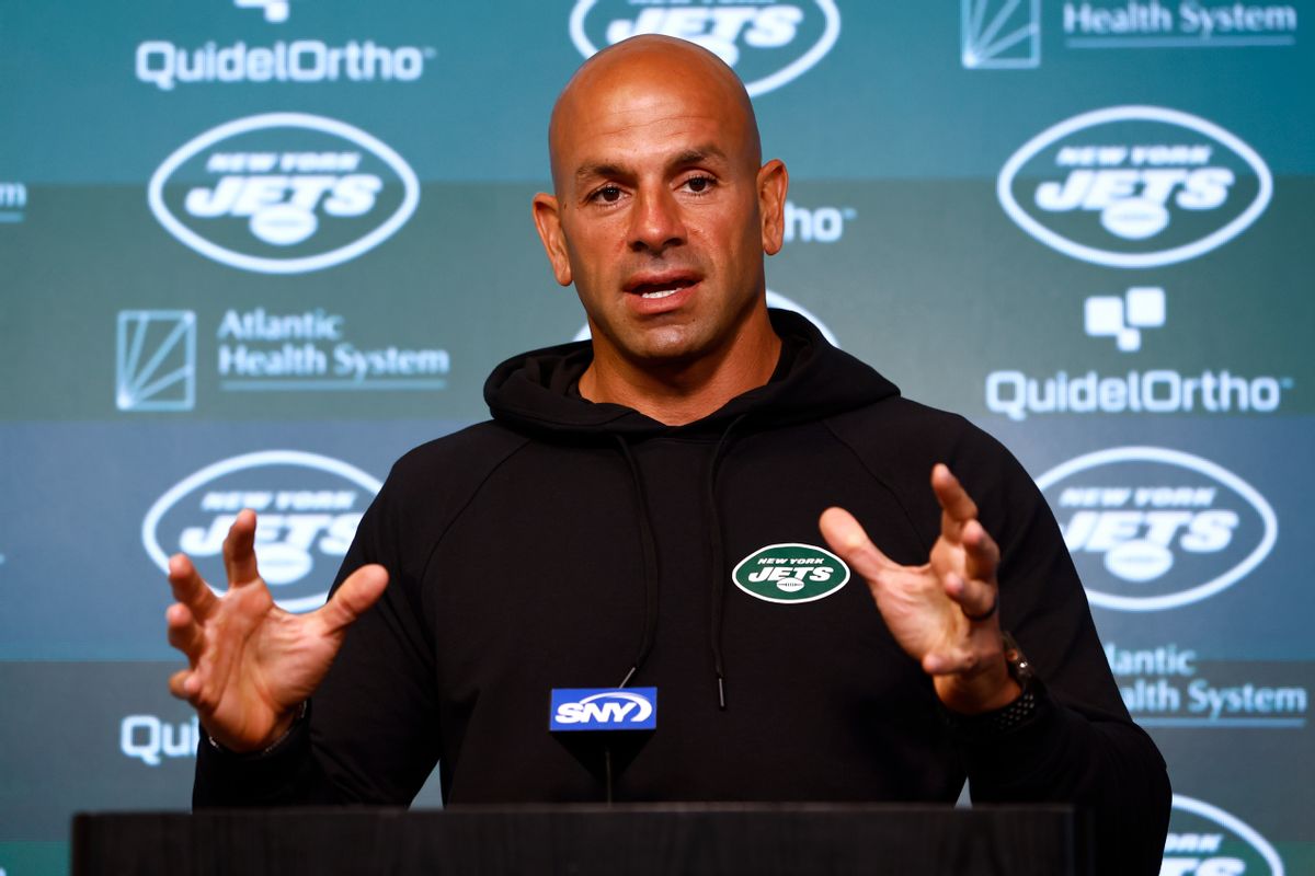 A Lebanese man wearing a black hoodie with a New York Jets patch on it stands at a podium.