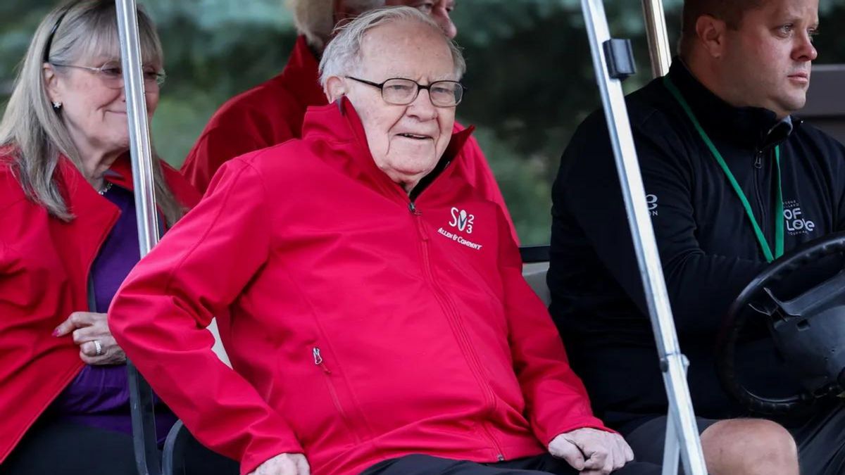 A white man sits in a golf cart surrounded by three other people.