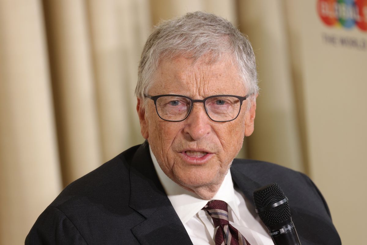 A white man wearing a black suit has his mouth slightly open.