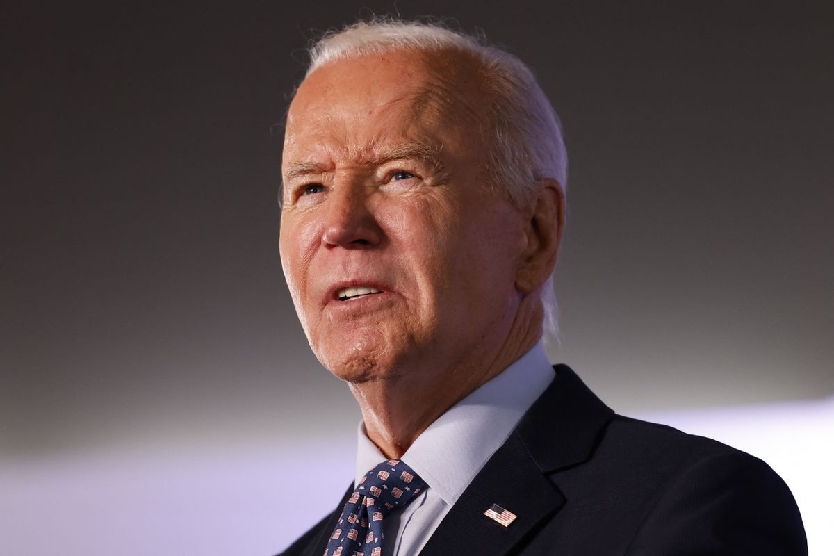 A white man wearing a black suit looks forward slightly to the left.