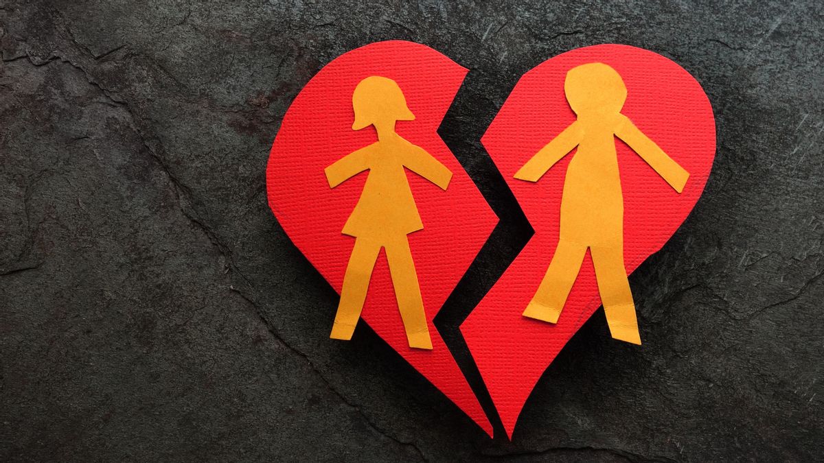 A heart cutout has two people signifying a woman and a man from left to right. The heart is broken down the middle.