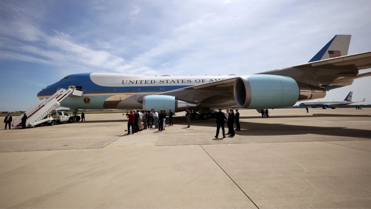 A large plane is shown that says UNITED STATES OF AMERICA. People stand around it.