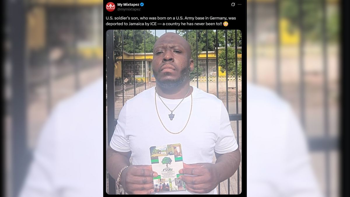A man with a shaved head and beard stands outside holding a booklet, wearing a white t-shirt, gold chain, and pendant. Behind him is a black metal fence and yellow building. Text of the X post above reads: “U.S. soldier’s son, who was born on a U.S. Army base in Germany, was deported to Jamaica by ICE — a country he has never been to!!”
