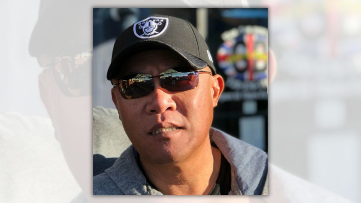 An Asian man wearing sunglasses and a hat is shown looking towards the camera.