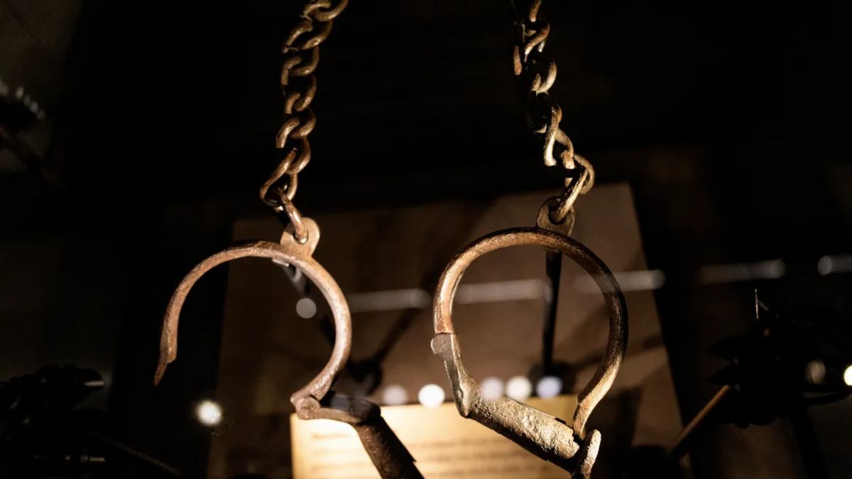A pair of what appear to be handcuffs hang down.