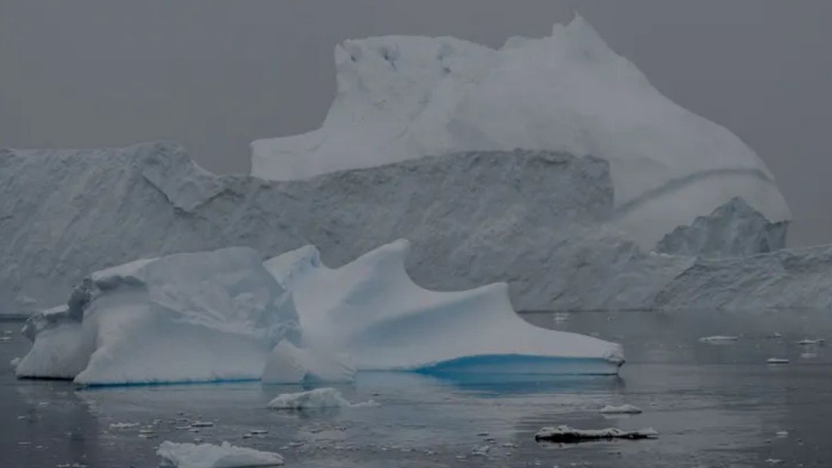 Large ice blocks are seen on top of water that is frozen over.