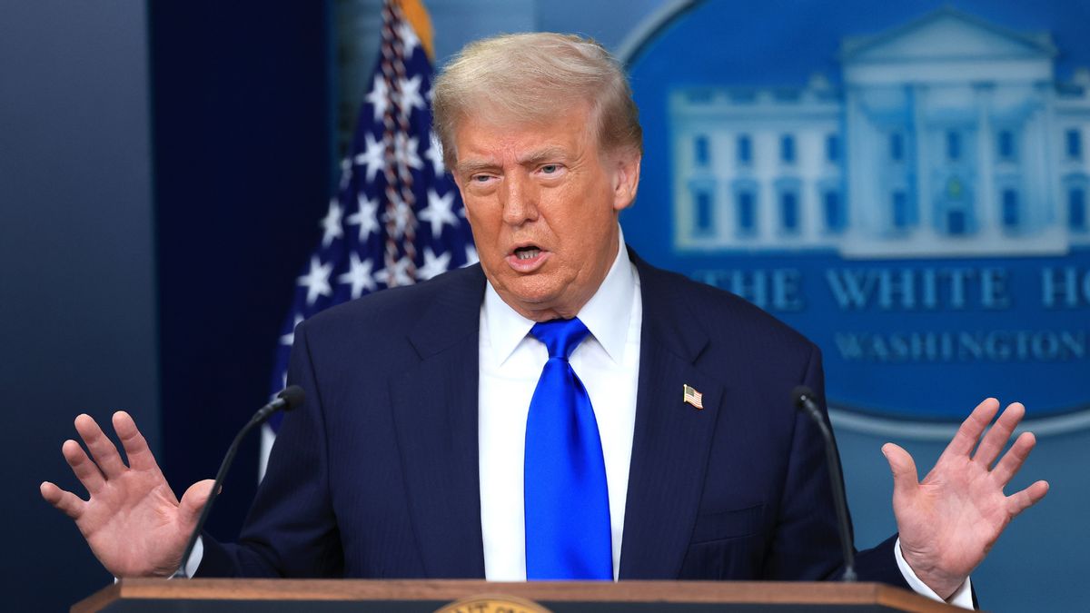 U.S. President Donald Trump, a white man in a dark suit, stands in front of a podium.