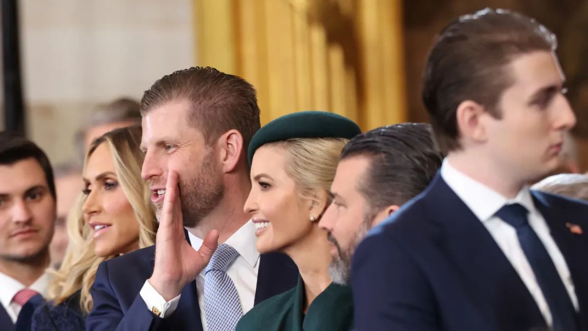 A group of white men and women stand near each other. our are looking to the left, while one on the right is looking in the opposite direction.
