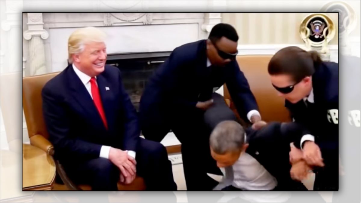 A white man sitting in a chair smiles as a Black man appears to be arrested by two other men wearing dark blue suits.
