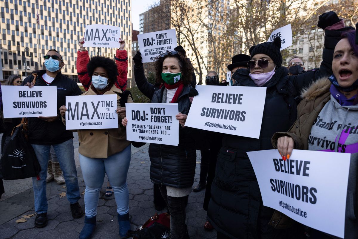 A group of people wearing masks hold signs that say "BELIEVE SURVIVORS," "MAX time for MAX well" and "DOJ: Don't forget! Epstein's clients are sex traffickers too"