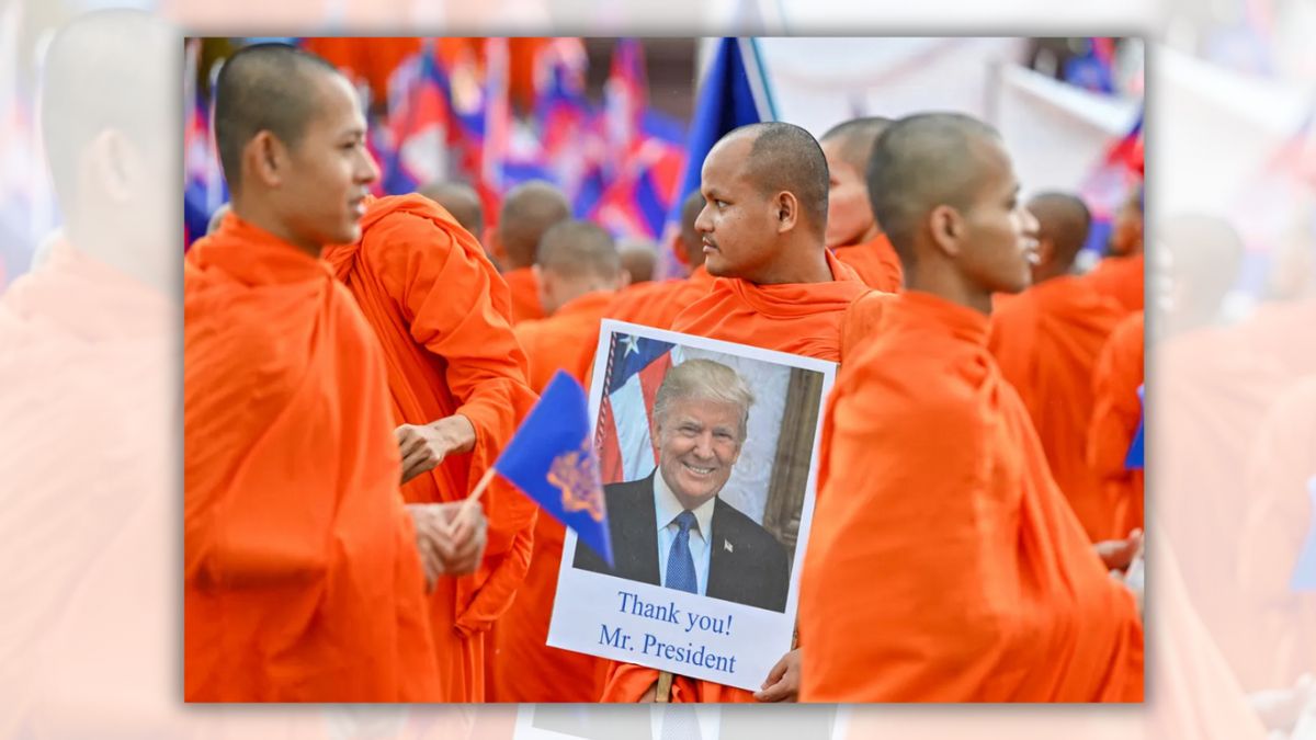 A group of Asian men with shaved heads wearing orange robes stand in a group. One is holding a sign with a picture of a white man smiling saying "Thank you! Mr. President."
