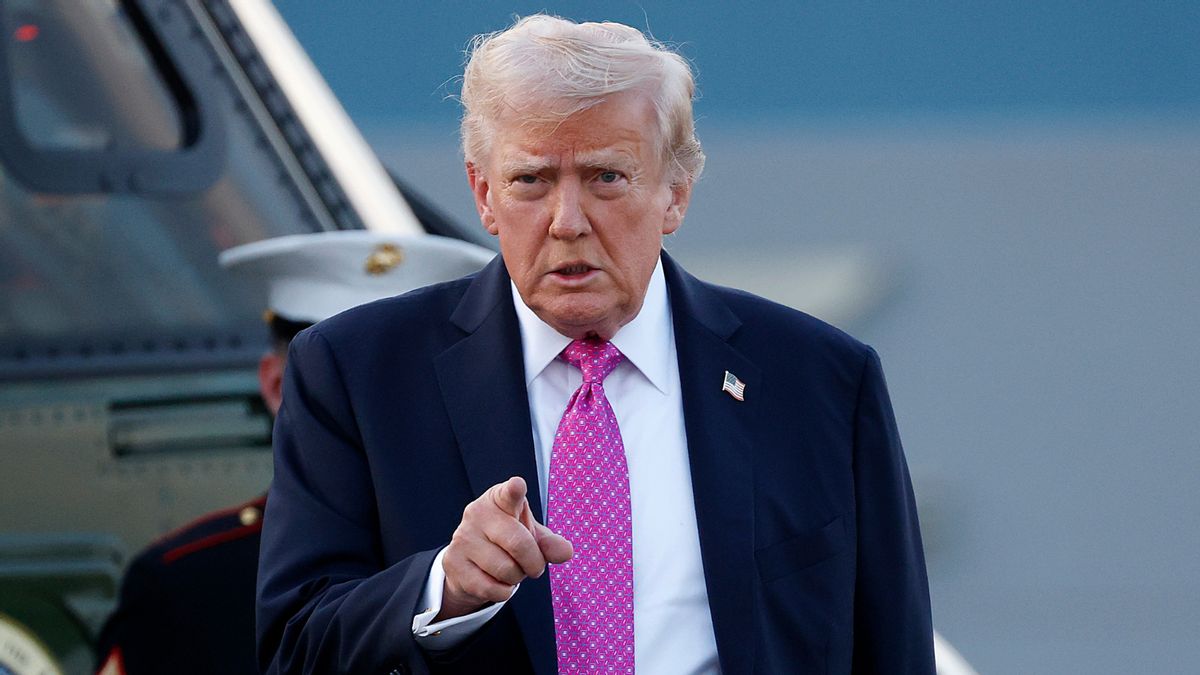 U.S. President Donald Trump, a tan white older man in a suit, points at the camera. 