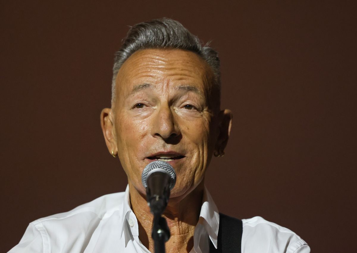 Bruce Springsteen, who has short gray hair, sings into a microphone.