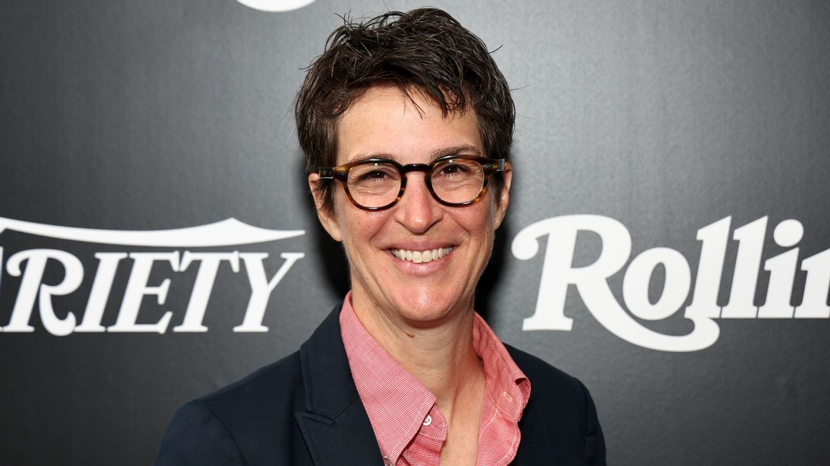 A white woman is shown smiling at the camera. 