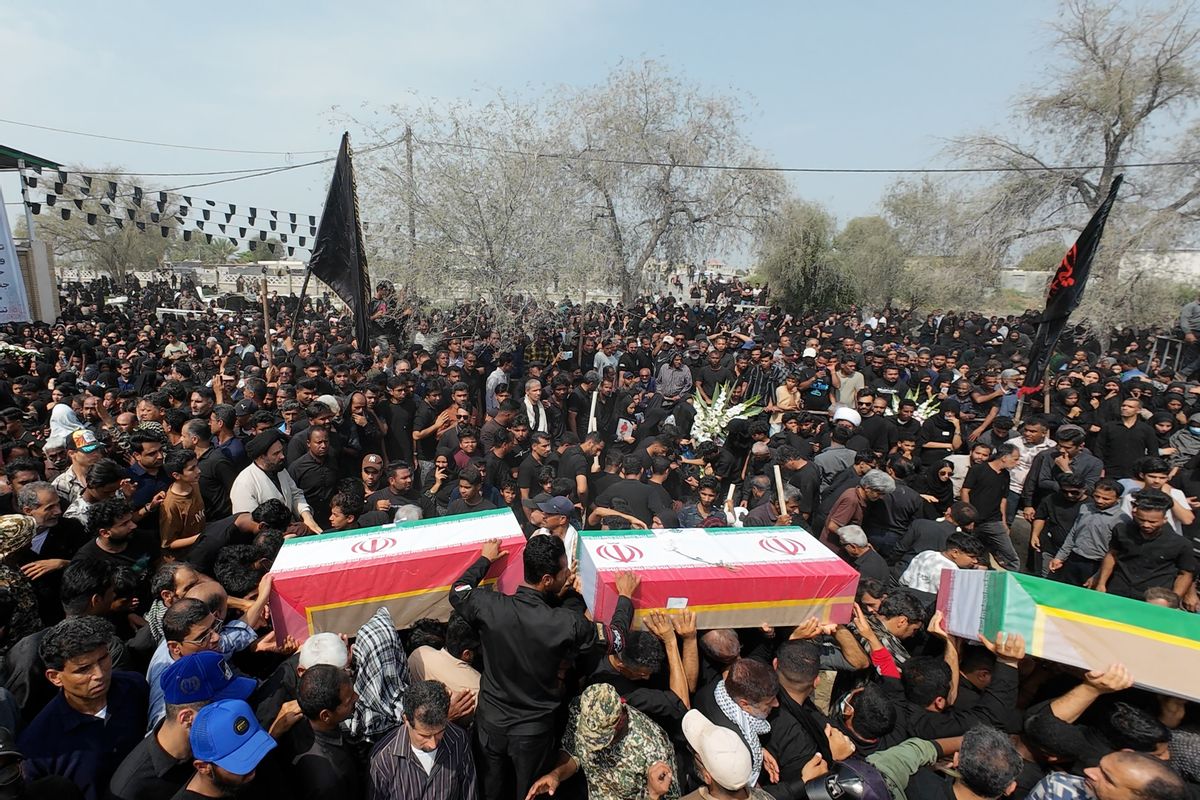 Large crowd gathers in Iran and holds coffins featuring Iranian flag to mourn children killed in Minab girls' school missile strikes.