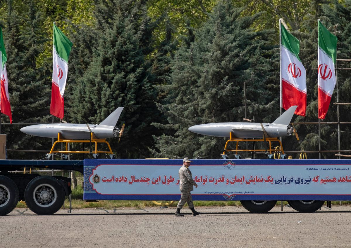 Two Iranian drones on a flatbed truck. Four Iranian flags fly in the background of the photo.