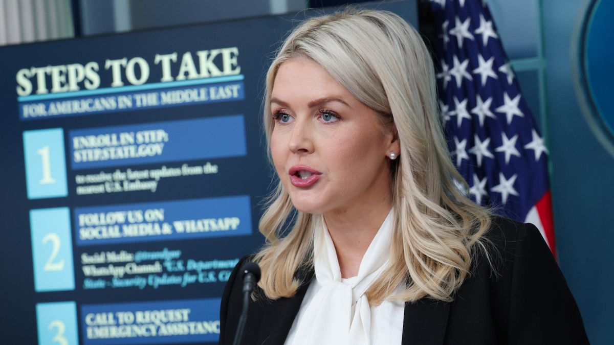 White House Press Secretary Karoline Leavitt, a white woman with blonde hair, speaks into a microphone while wearing a white blouse and black blazer.