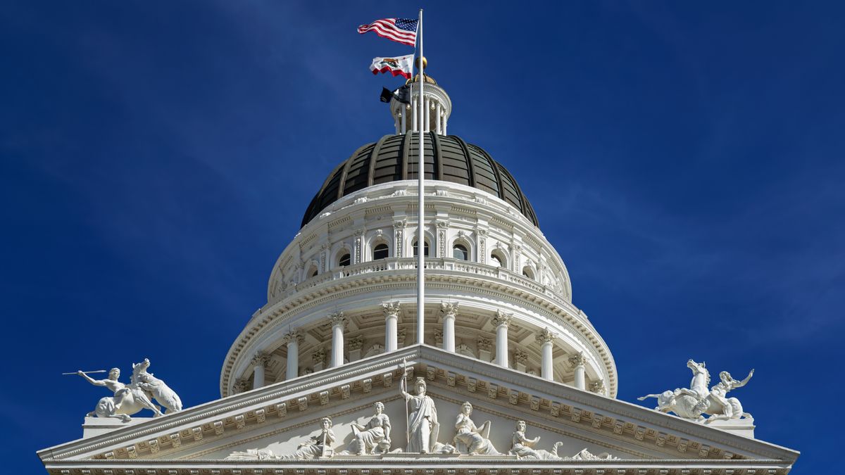 Photo shows the top of the California State Capitol in California against a blue sky.