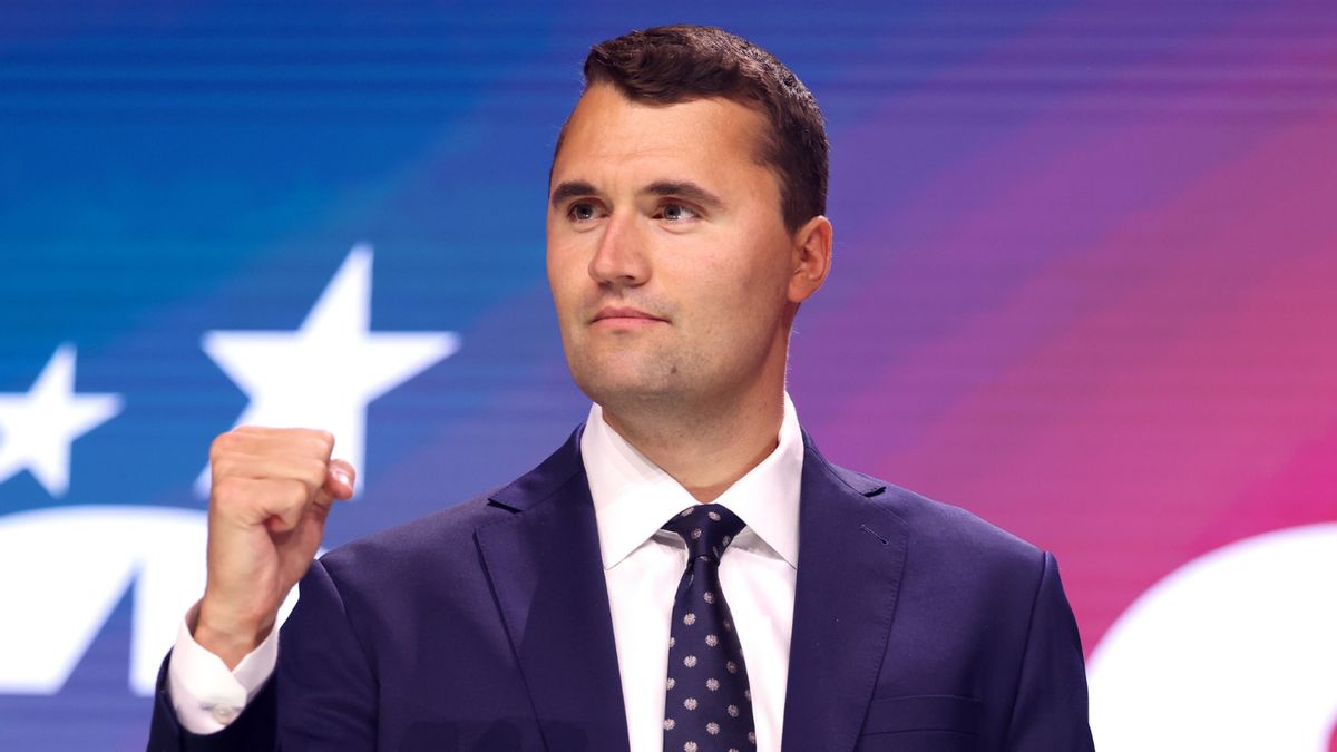 An image of Charlie Kirk, a younger white man with short brown hair in a suit fist pumping. 