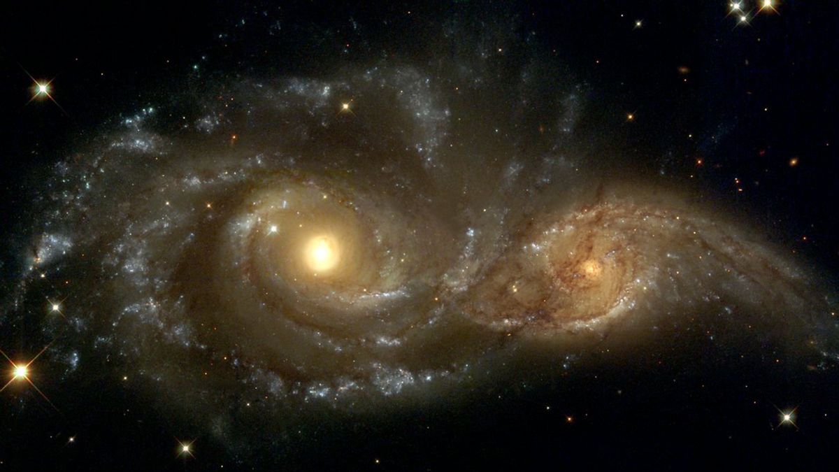 In the direction of the constellation Canis Major, two spiral galaxies pass by each other.