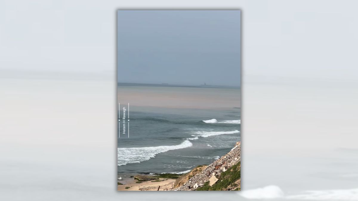 Screenshot from video claiming sewage dam was opened into Gaza water. It's an image of the ocean from the vantage point of a dune or cliff. While the nearby water is bluish, the more distant water is brown.