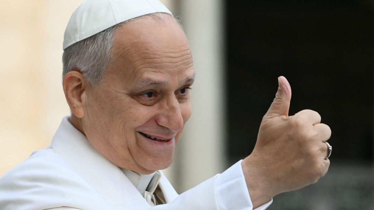 A photo shows Pope Leo XIV wearing white, including a white head covering, and giving a thumbs up to a crowd.