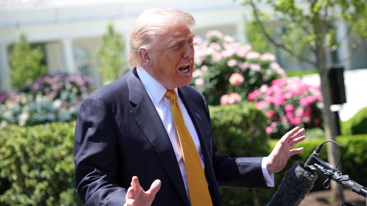 U.S. President Donald Trump, wearing a suit, gestures and speaks into a microphone.