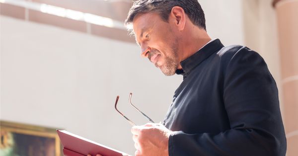 Priest reading from a book.