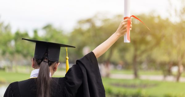 Back of student holding diploma at graduation