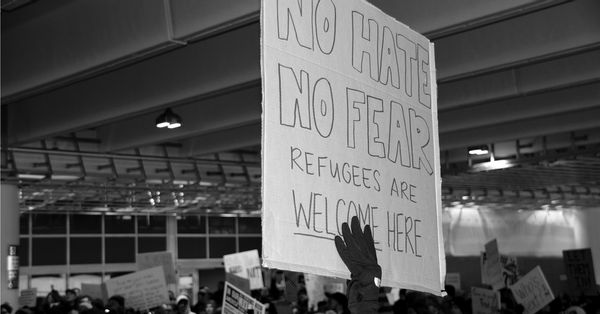 Protester holding sign that reads: "No Hate, No Fear, Refugees Are Welcome Here"