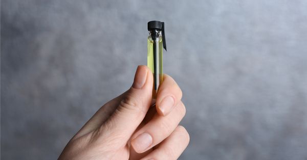 hand holding perfume sample bottle