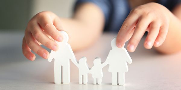 Child holding a paper cutout of a family.