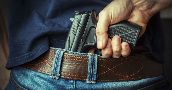 Man pulling out hidden gun