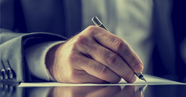 Close-up of man hand writing a letter