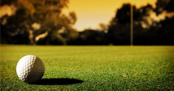 Golf ball on course at sunset