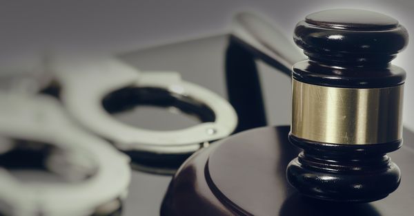 Close up of gavel, handcuffs in background